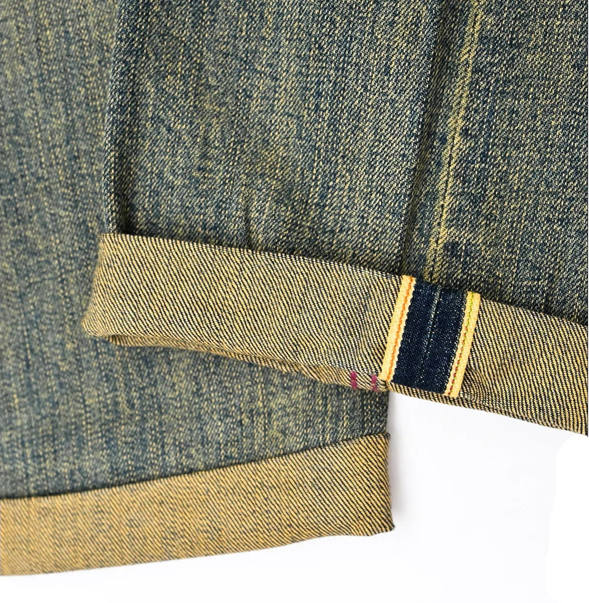 Close-up of denim fabric showing cuff details in blue and yellow stitching, showcasing quality craftsmanship.