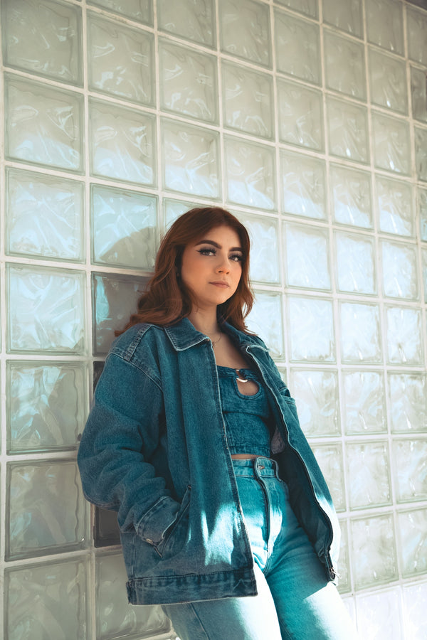 a woman standing in front of a glass block wall