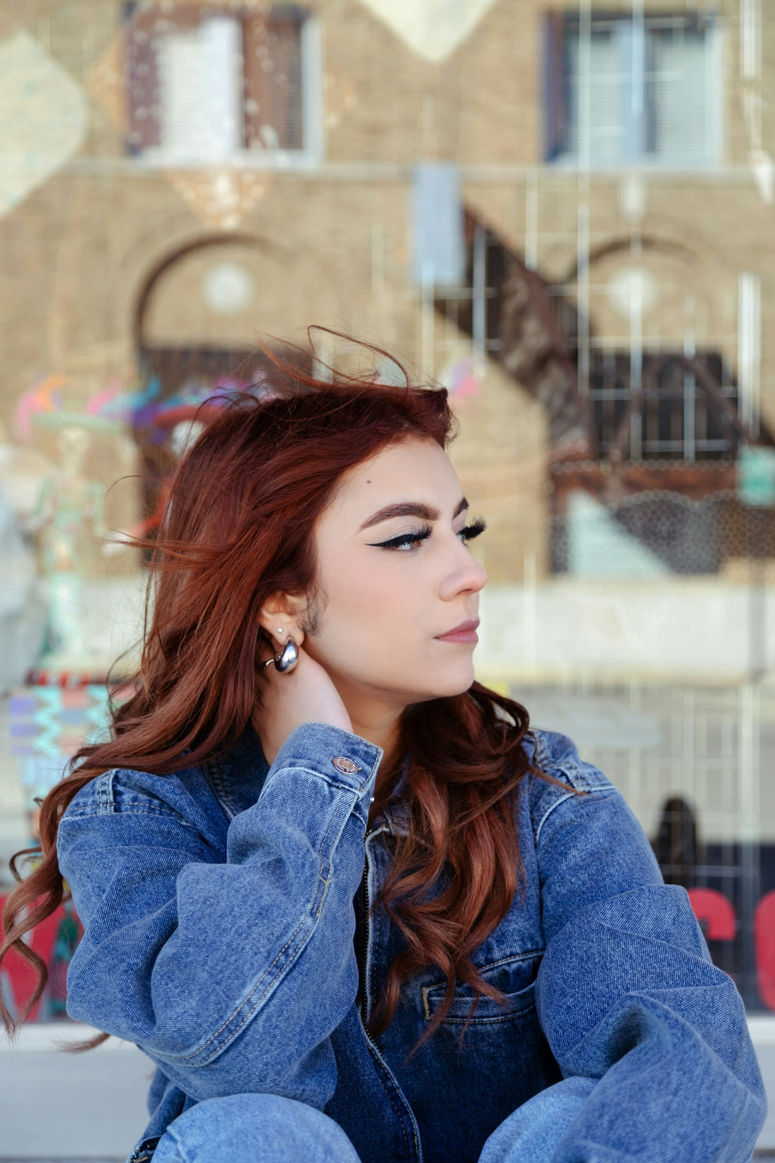 a woman with red hair sitting on the ground