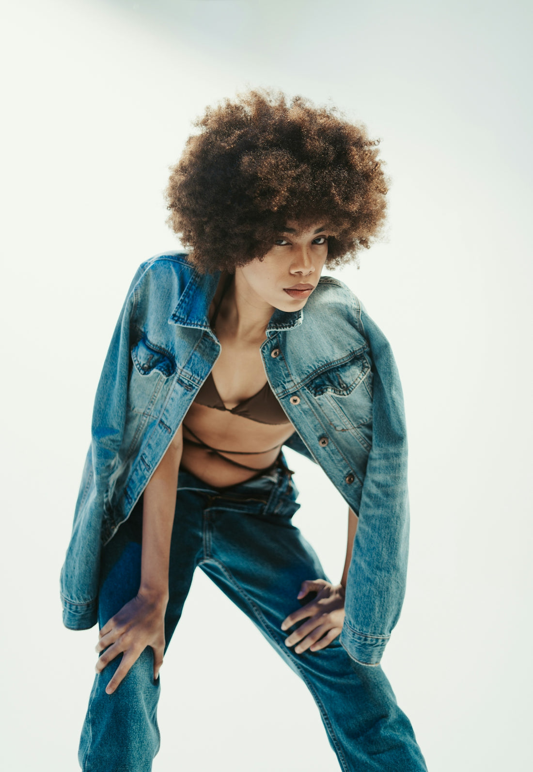 a woman wearing a jean jacket and jeans