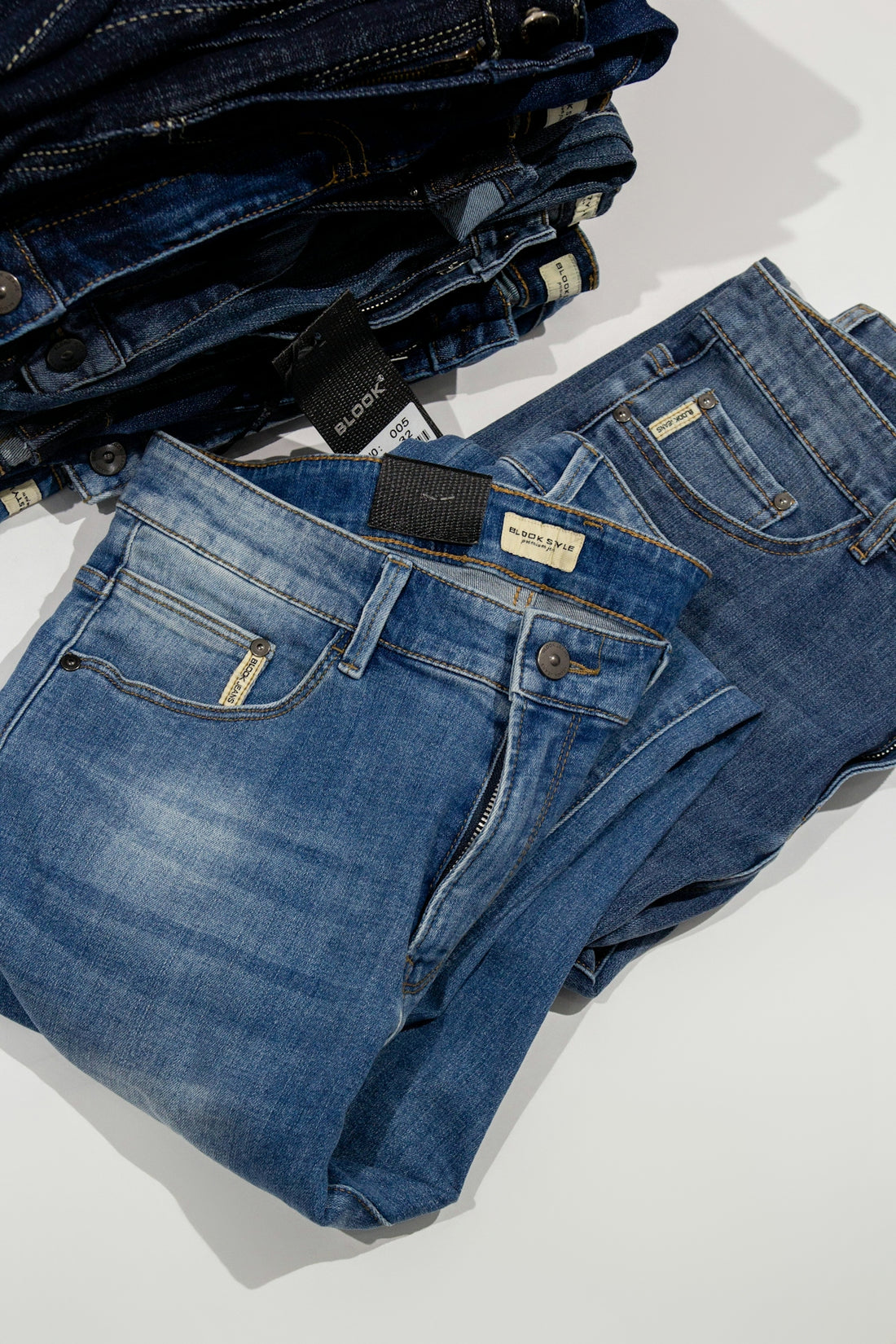 a pile of jeans sitting on top of a white table