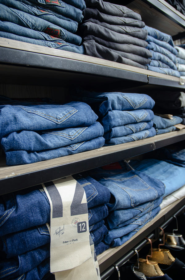 a rack of jeans in a store with price tags