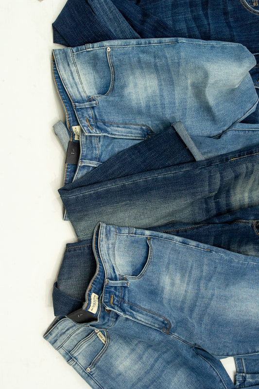 A pile of jeans laying on top of each other