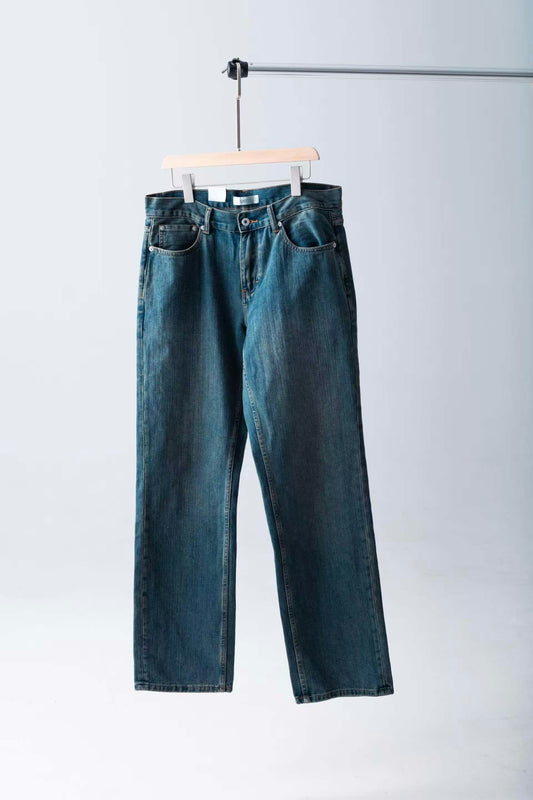 Jeans hang on a wooden hanger.