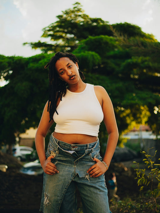 Woman in white tank top and denim overalls